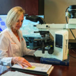 Dr. Debra Miller looks over slides for an amphibian pathogen.