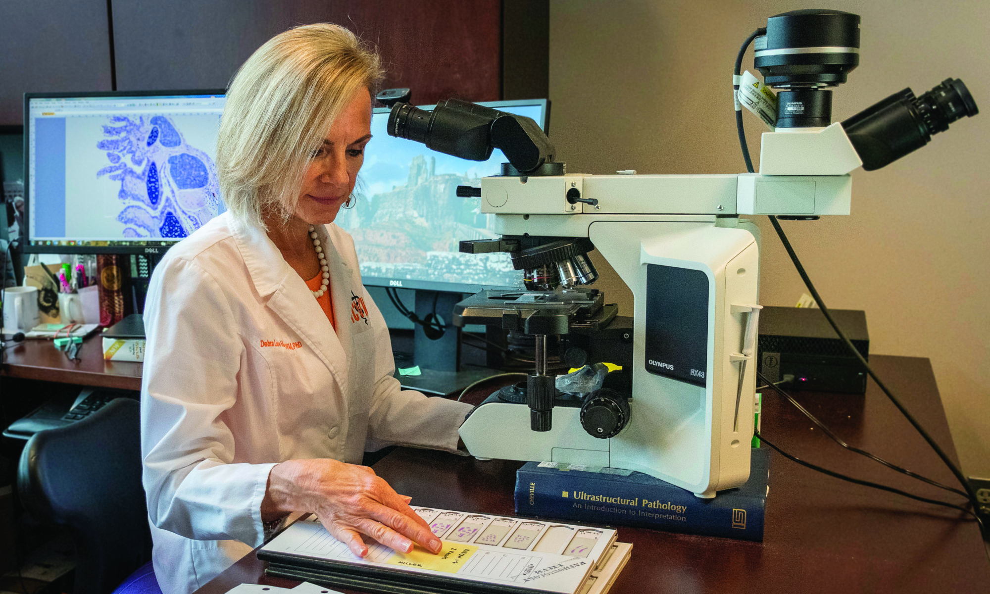Dr. Debra Miller looks over slides for an amphibian pathogen.