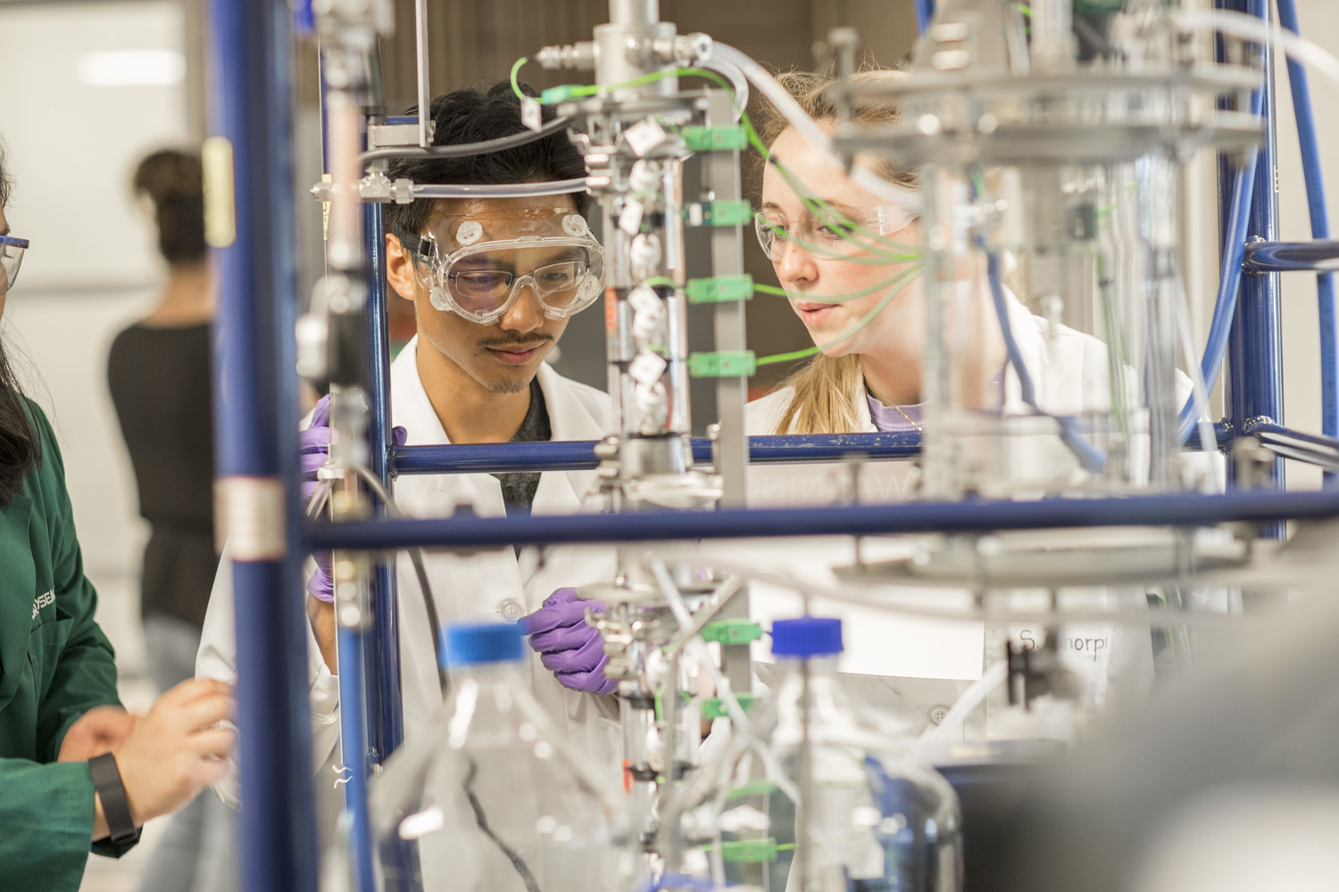 Students and faculty using equipment in the lab while wearing safety equipment. Note: Dr. Rosemary Le has left the university and the students in the photo have all graduated. Photography by Jack Parker.